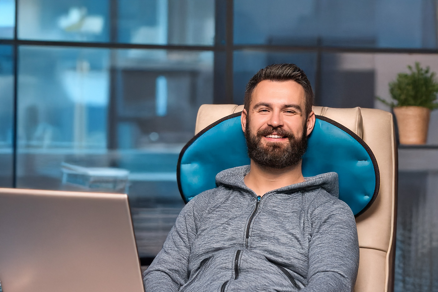 Ein Mann sitzt im Büro auf einem Bürostuhl mit einer Medithera Magnetfeldmatten für mehr Entspannung